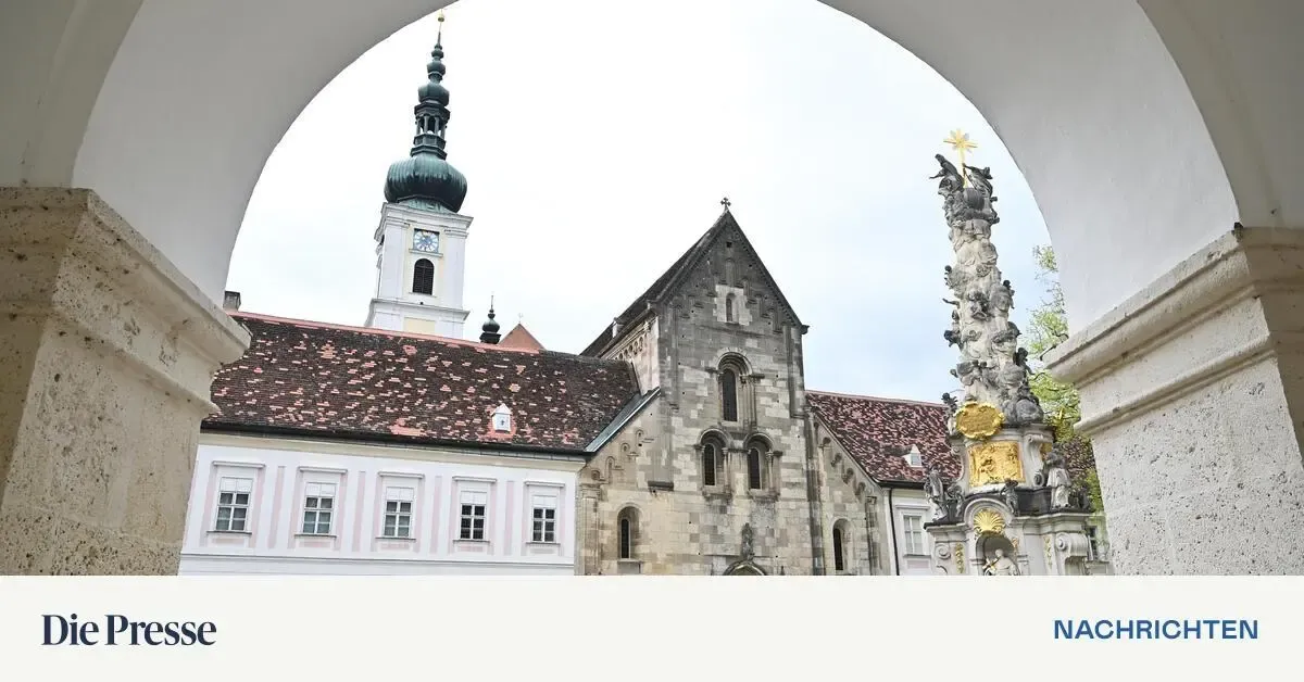 Eine alte Kirche mit hohem Turm, Kreuz und kunstvollen Statuen ziert die Szene. Das Gebäude hat bogenförmige Fenster und ein rotes Dach.