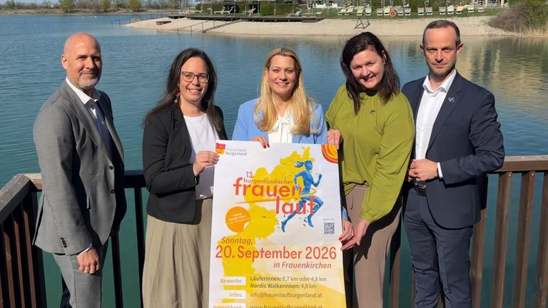 Four women stand by a lake holding a sign for the 13th Burgenland Frauenlauf on September 20, 2026 in Frauenkirchen, with various distances available for runners and walkers.
