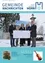 Eine Gruppe von Menschen steht im Schnee und hält ein weißes Plakat in der Hand, alle tragen Winterkleidung. Sie scheinen für ein Foto zu posieren. Links steht ein Weihnachtsbaum.