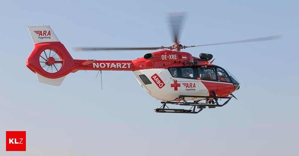 A red and white helicopter labeled NOTARZT and ARBO flies in the sky with a red cross on the side.
