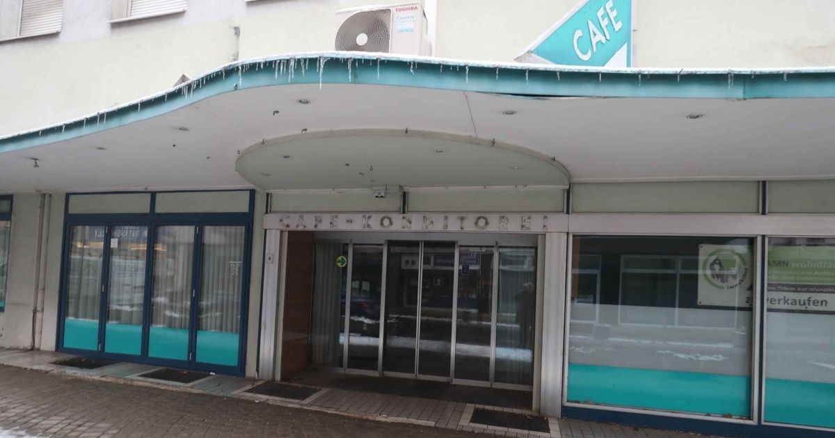 Eingang zum Café mit Glastüren, einem weißen Vordach und Eistropfen auf dem Dach. Ein blaues Schild über dem Eingang steht CAFE.