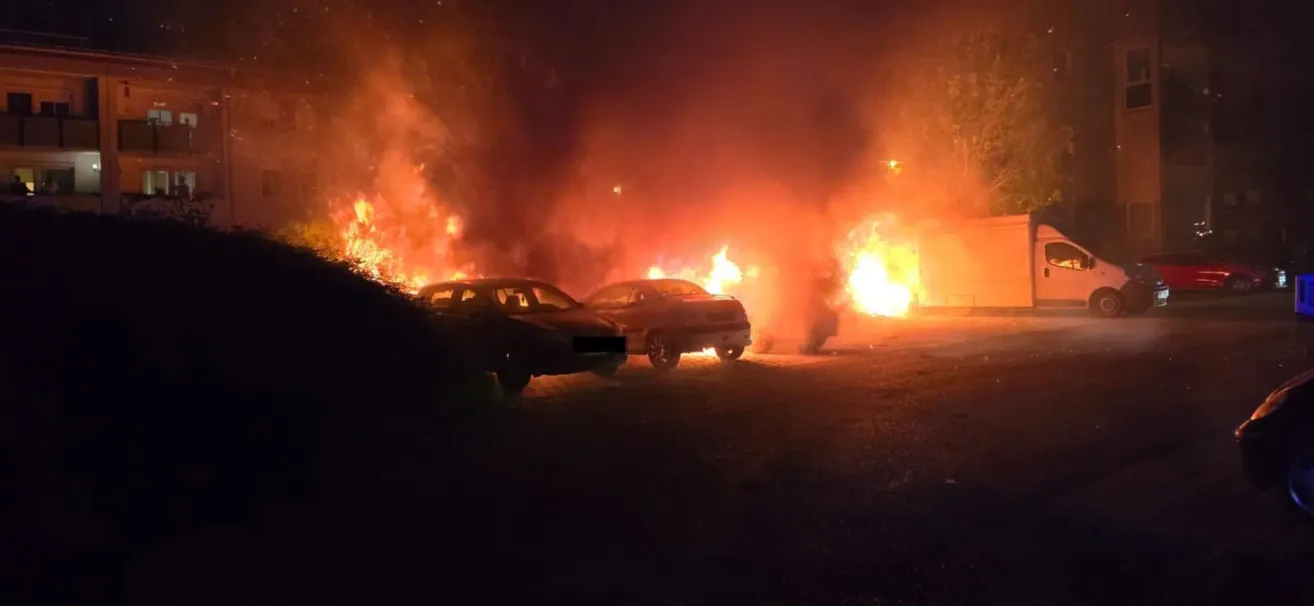 Ein Feuer hat sich in der Nacht entzündet und mehrere Autos verschlungen, was zu einer chaotischen Szene mit intensiven Flammen führt.