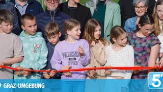 Children holding a ribbon, likely at an event. One girl wears a shirt that says 'FRIENDS SINCE EVER.' Behind them are adults, including a man in glasses.