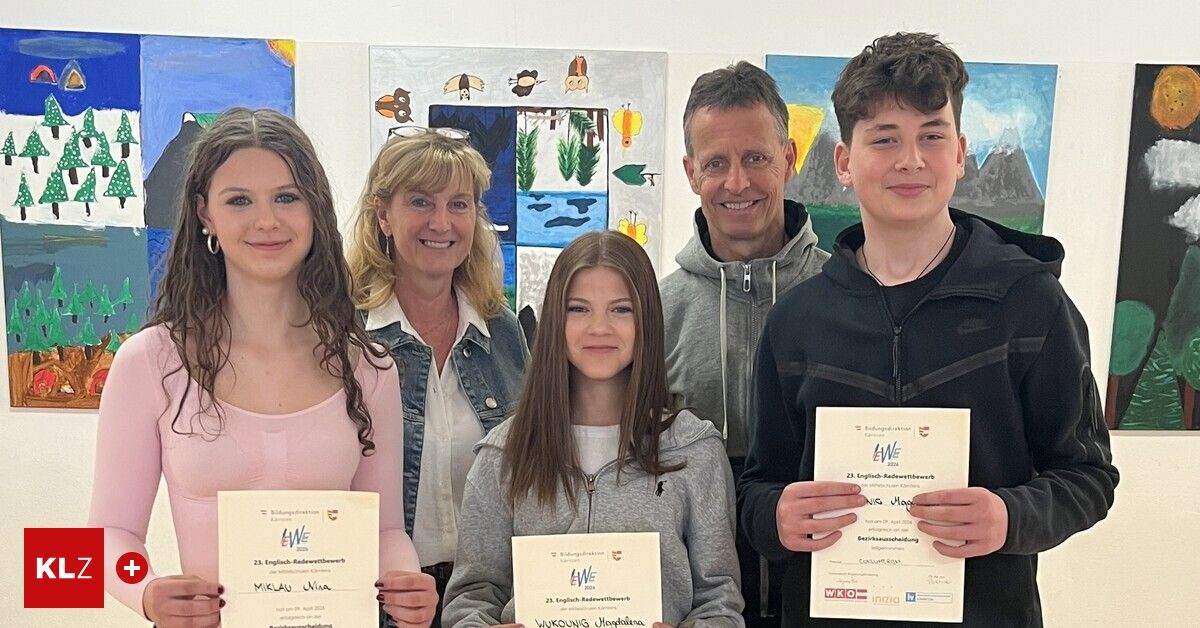 Five individuals, two women and three men, smiling in front of a white wall with colorful paintings. The woman on the left holds a certificate. The girl in the middle holds a certificate with the words 'Wukouning Hochstein'. The man on the right holds a certificate with 'WKO inzia tv'.