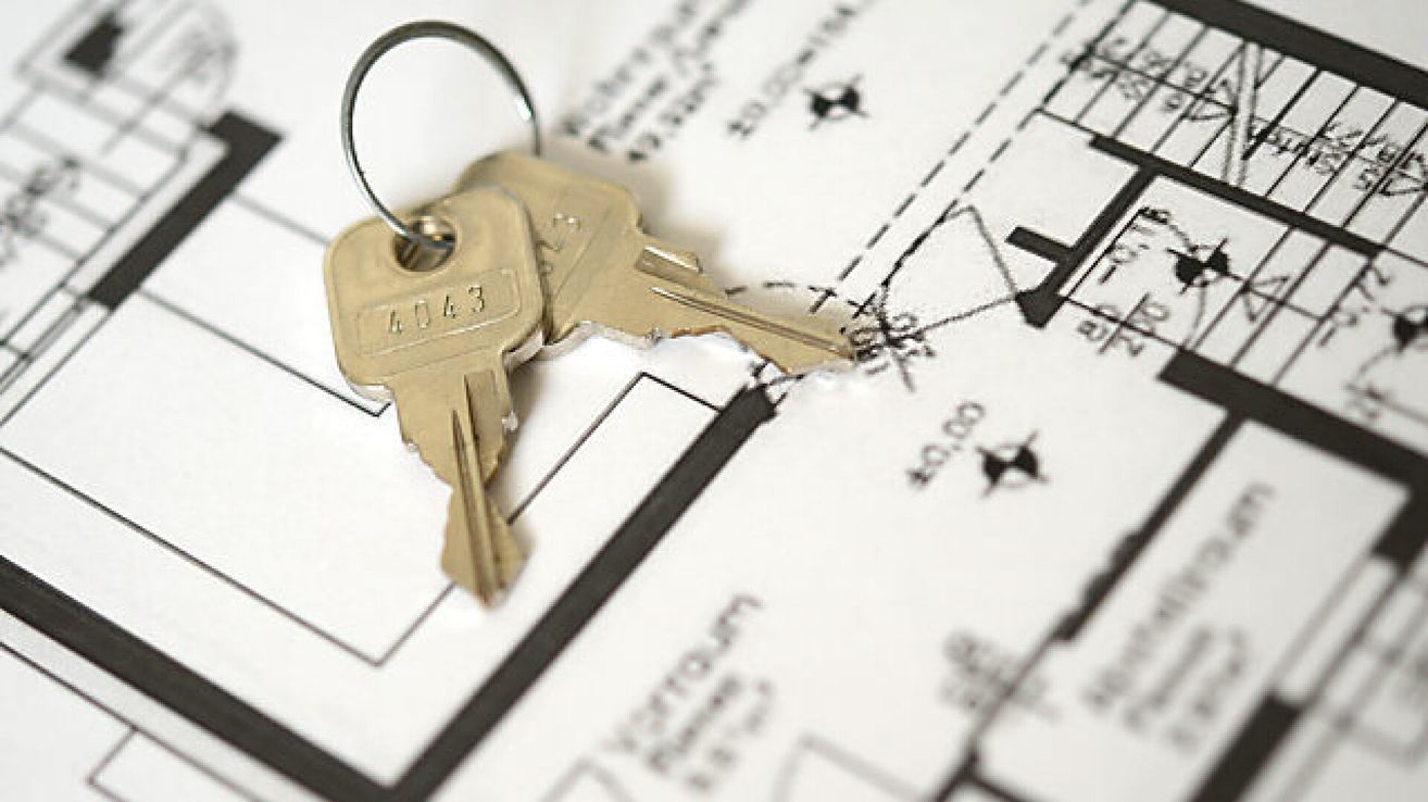 A pair of golden keys labeled 4043 on a printed architectural plan.