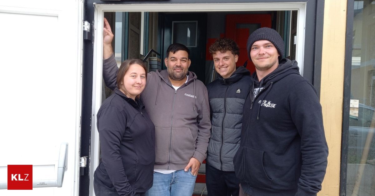 Four individuals are standing together in front of a doorway. Two men and two women. One man has his hand on the door frame.