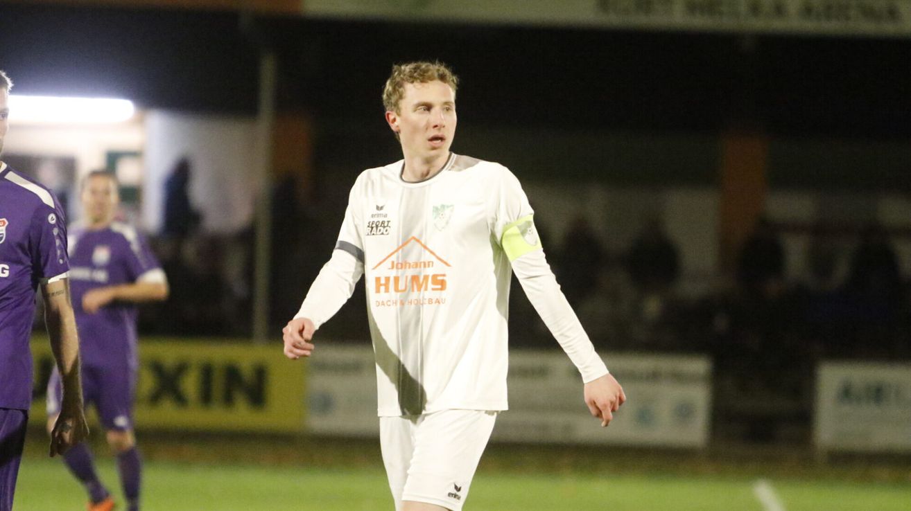 A soccer player in white uniform runs on the field. The jersey says Johann Hums.