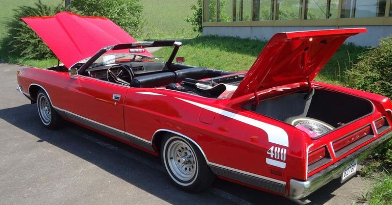 Ein roter Cabriolet mit der Nummer 488, der auf der Straße mit offenem Motorhauben steht.