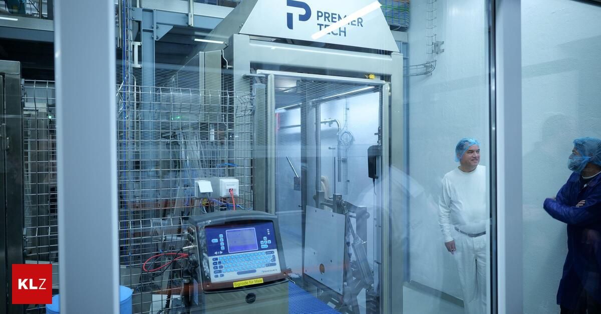 Ein Techniker steht neben einer Premier Tech-Maschine, die in einer Glaskammer eingeschlossen ist, in einer sauberen Umgebung.
