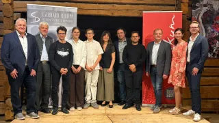 A group of people stand on a stage with a wooden background. Banners behind them read 'Gerhard Schöpp' and 'Kur'.