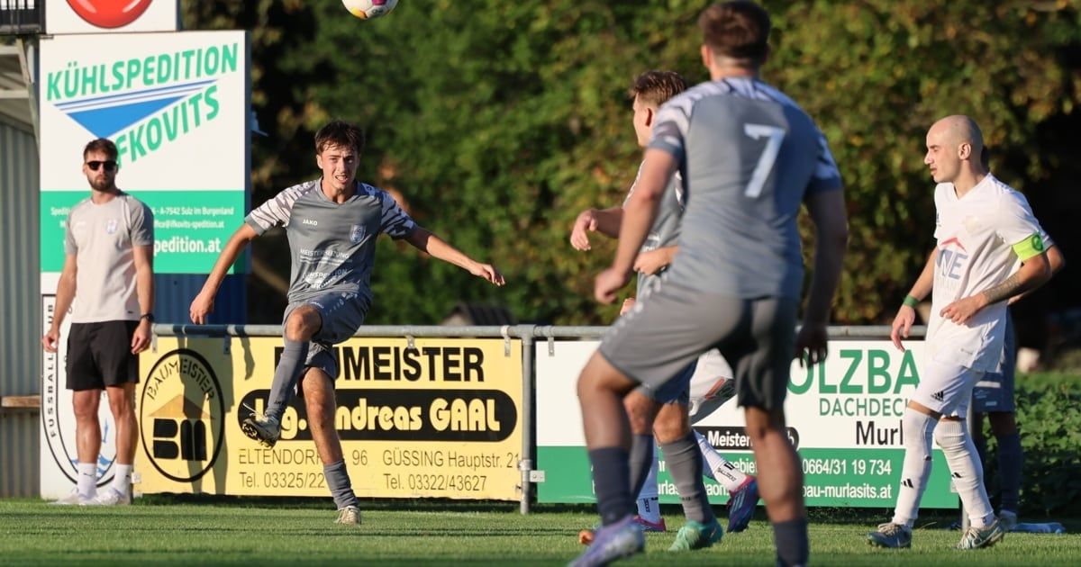 Drei Fußballspieler befinden sich auf einem Spielfeld, einer kickt den Ball. Der Spieler auf der linken Seite trägt ein Trikot mit der Nummer 7. Hinter ihnen befinden sich Banner mit Texten und Zahlen.