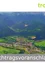 Luftaufnahme eines grünen Gebirgstals mit einem Dorf unten. Der Text 'Nachtragsvoranschlag 2' ist unter dem Bild zu sehen.