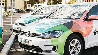 Ein weißes Auto mit einem farbenfrohen Design ist neben anderen Fahrzeugen auf der Straße geparkt. Das Nummernschild lautet G0TIM8.