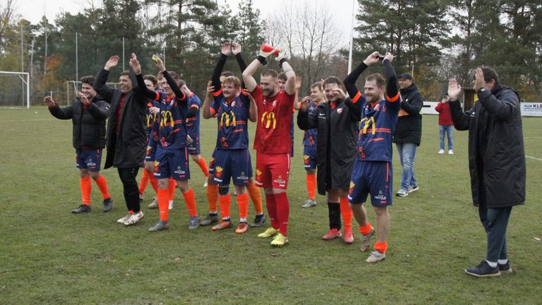 Eine Gruppe von Fußballspielern feiert auf einem Rasenfeld, mit Uniformen, die McDonald's-Logos tragen. Sie haben verschiedene Farben und stehen mit erhobenen Händen.
