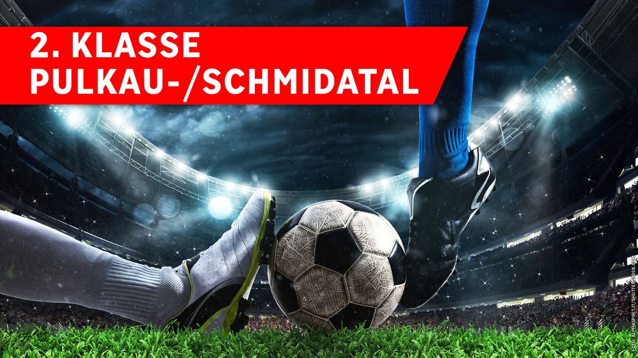 Ein Fußballspieler tritt einen Ball auf einem grünen Feld, der unscharf im Hintergrund eines Stadions steht. Der Spieler trägt blaue Socken und schwarze Stollenschuhe. Über dem Spieler steht roter Text 'U-SCHMIDTAL'.