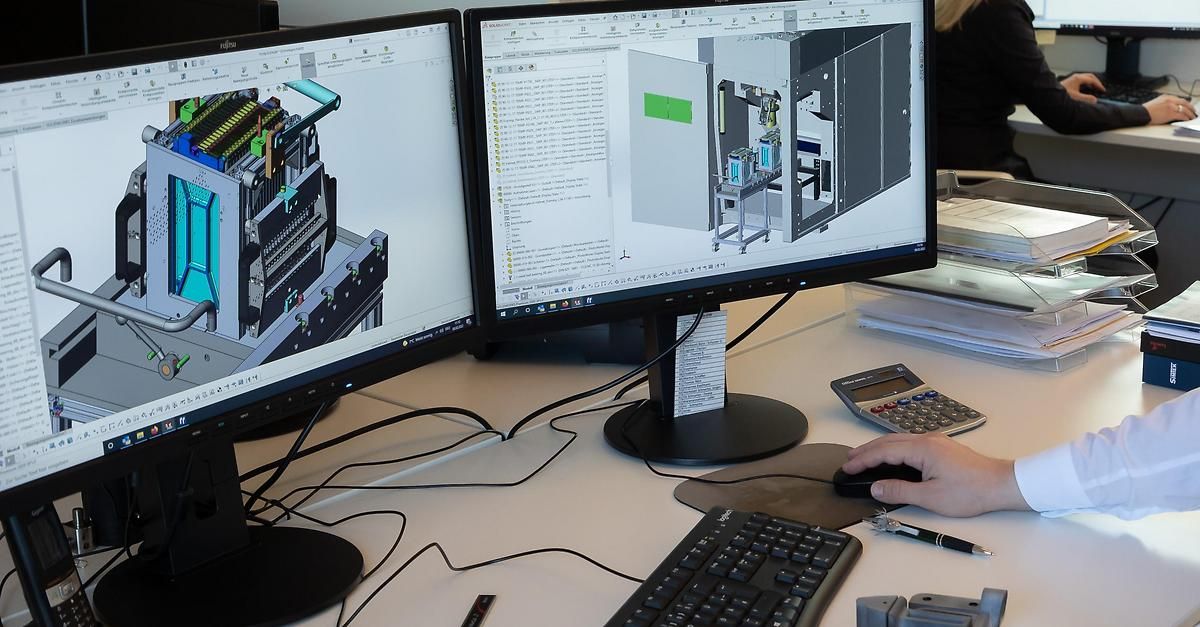 Zwei Monitore zeigen 3D-Modelle, einer mit einer Leiterplatte und ein anderer mit einem mechanischen Design. Eine Hand benutzt eine Computermaus.