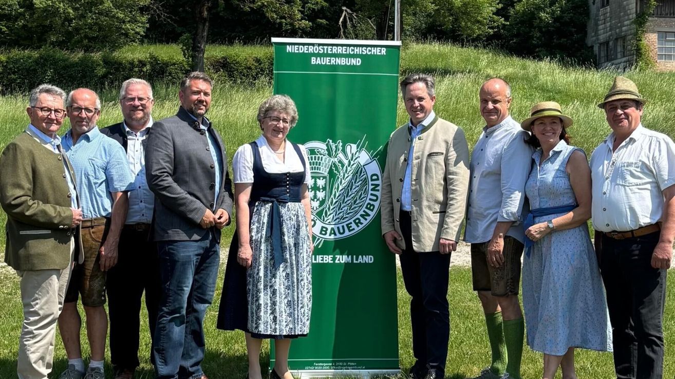 Fünf Personen stehen vor einem grünen Banner mit den Worten 'Niederosterreichischer Bauernbund' und 'Liebe zum Land'. Sie lächeln und scheinen für ein Foto zu posieren.