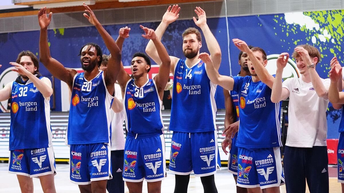 Eine Gruppe von Basketballspielern in blauen Trikots mit den Nummern 30, 14 und 20 feiert einen Sieg. Sie heben die Hände und scheinen zu schreien. Der Spieler in der Mitte hat einen Bart. Das Bild hat einen Wasserzeichen mit den Texten 'burgen land' und 'ROBNER'.