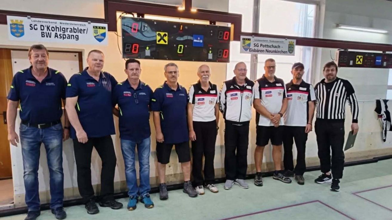 Sechs Männer in Sportbekleidung stehen vor einer Anzeigetafel. Sie scheinen für ein Foto zu posieren.