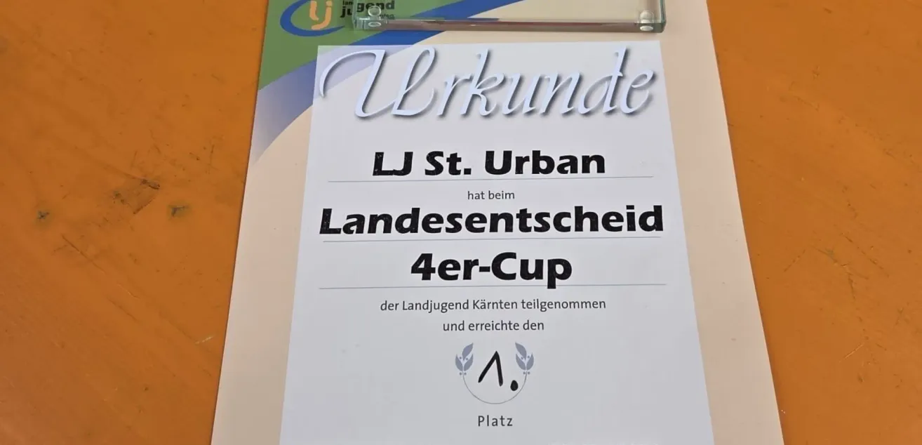 Ein Zertifikat zeigt, dass LJ St. Urban den ersten Platz beim Landesentscheid 4er-Cup für die Jugend Kärntens erreicht hat. Das Dokument ist auf einem farbenfrohen Hintergrund ausgestellt.