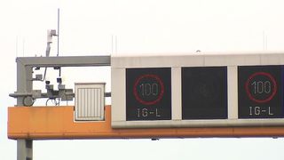 A highway speed limit sign displays 100 km/h, with a red circle around the number indicating an active speed limit.