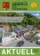 Eine Luftaufnahme einer Veranstaltung in einem neuen Gebäude mit Solarmodulen, vielen Menschen und Häusern in Arnfels, Steiermark.