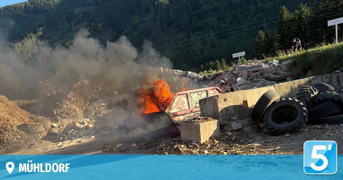 Ein LKW brennt mit dickem Rauch in der Nähe eines Haufens Schutt, Betonblöcke und Reifen.