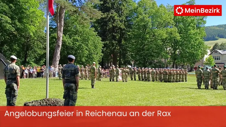 A military parade in Reichenbach on the Rax, with soldiers standing in formation under trees with spectators watching.