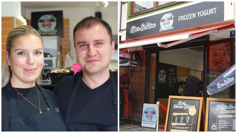 Zwei Männer in Schürzen stehen neben einem Geschäft mit einem Schild 'Der Schone Frozen Yogurt'. Im Inneren sind Artikel ausgestellt, und ein Kreidetafel-Menü ist sichtbar.