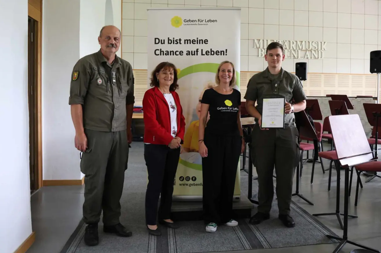Vier Personen stehen hinter einem Banner mit der Aufschrift Du bist meine Chance auf Leben. Ein Mann auf der rechten Seite hält eine Urkunde.