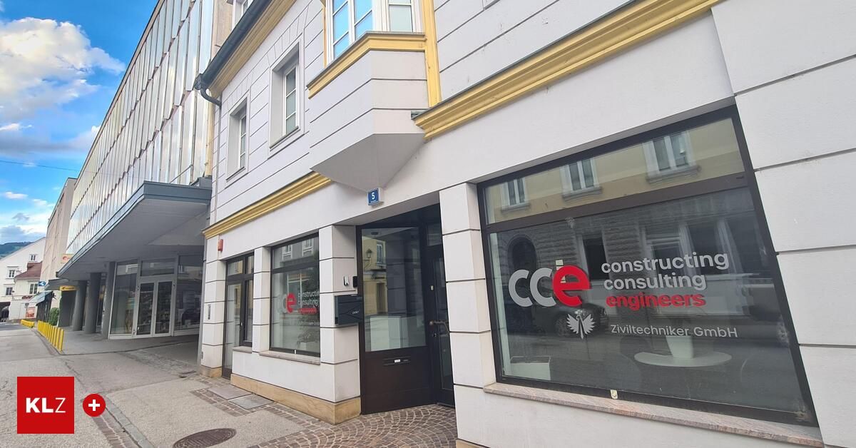 Das Äußere eines modernen Bürogebäudes zeigt eine Glastür mit dem Namen CCe Consulting Engineers, die nahegelegene Gebäude reflektiert.