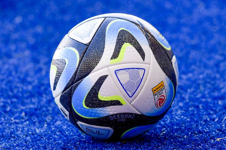 Ein Fußball mit blauem, weißem und schwarzem Design liegt auf einem blauen Feld. Der Ball hat weiße und grüne Akzente und zeigt das Wort 'Admira' und ein Logo.