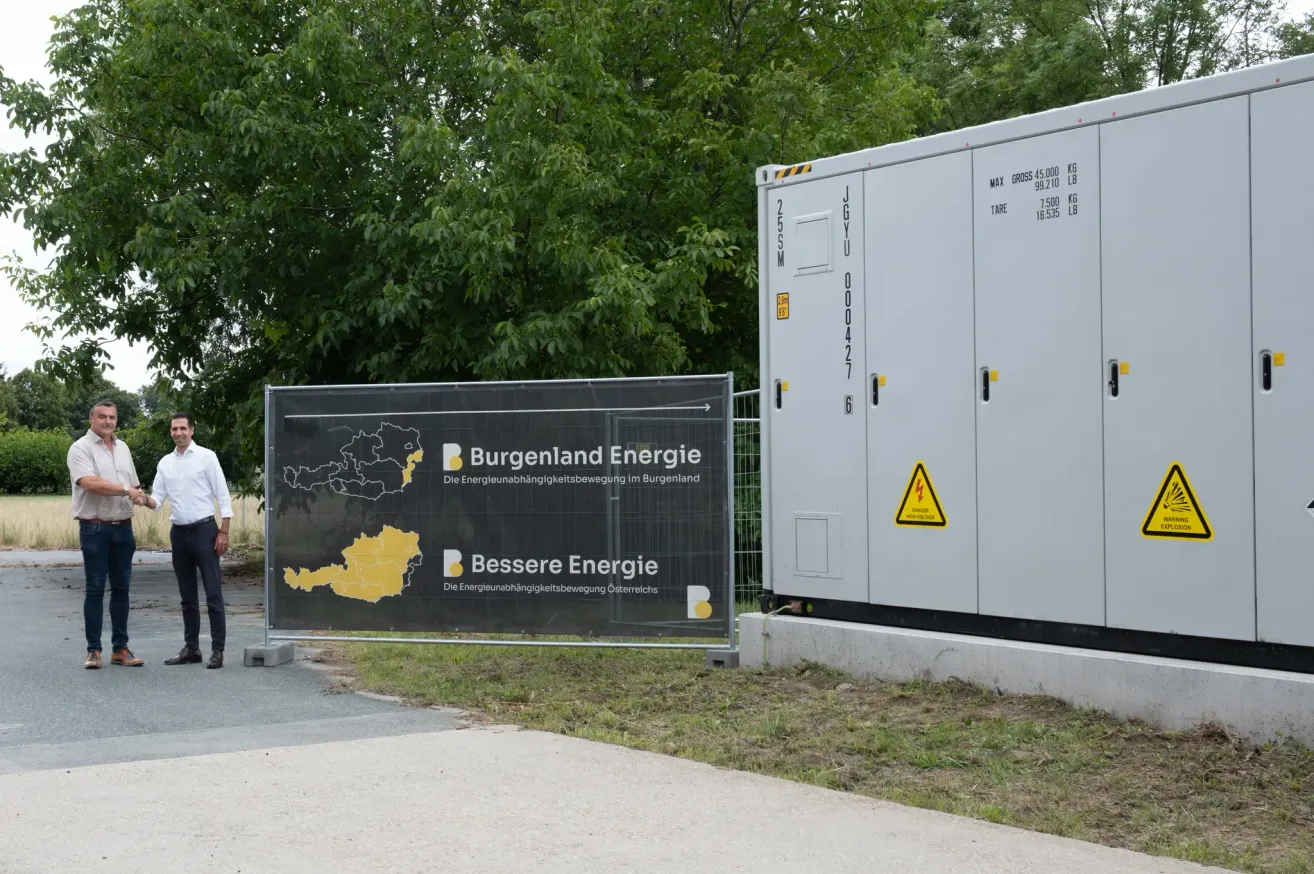 Ein Schild für Burgenland Energie steht neben einem Generator. Ein gelbes Dreieck mit Ausrufezeichen befindet sich am Generator.