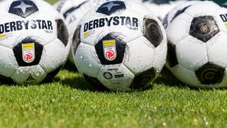 Nahaufnahme von DerbyStar-Fußballbällen, feucht vom kürzlichen Spiel, einer zeigt deutlich das Bundesliga-Liga-Logo.