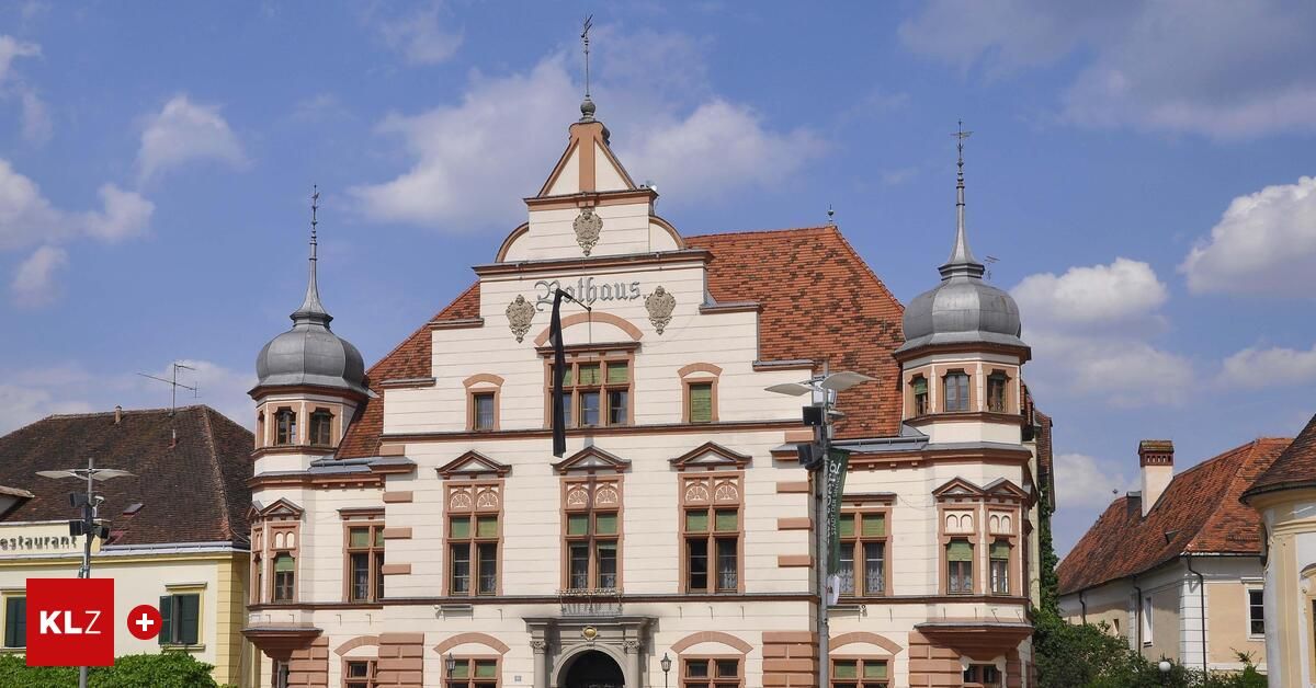 Ein altes Gebäude mit rotem Dach und weißen Wänden, mit großen Fenstern, kunstvollen Verzierungen und einer Uhr in der Mitte. Das Gebäude hat drei kuppelförmige Türme an der Vorderseite.