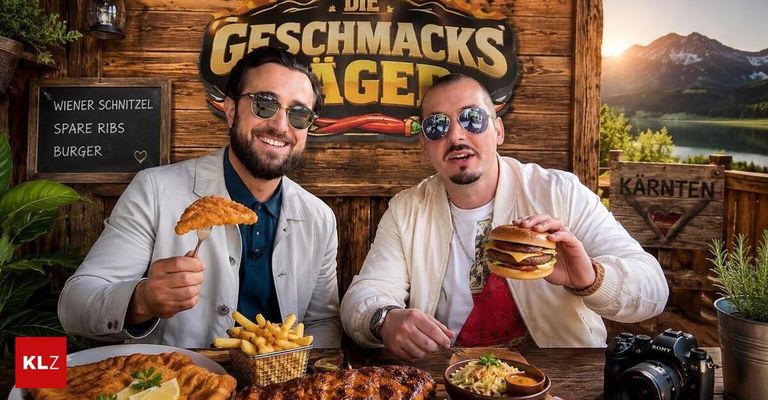 Zwei Männer sitzen an einem Tisch mit Essen. Einer hält einen frittierten Fisch und der andere einen Hamburger. Sie tragen beide Sonnenbrillen. Hinter ihnen ist eine Holzwand mit einem Schild, das 'Die Geschmacks Ager' steht.