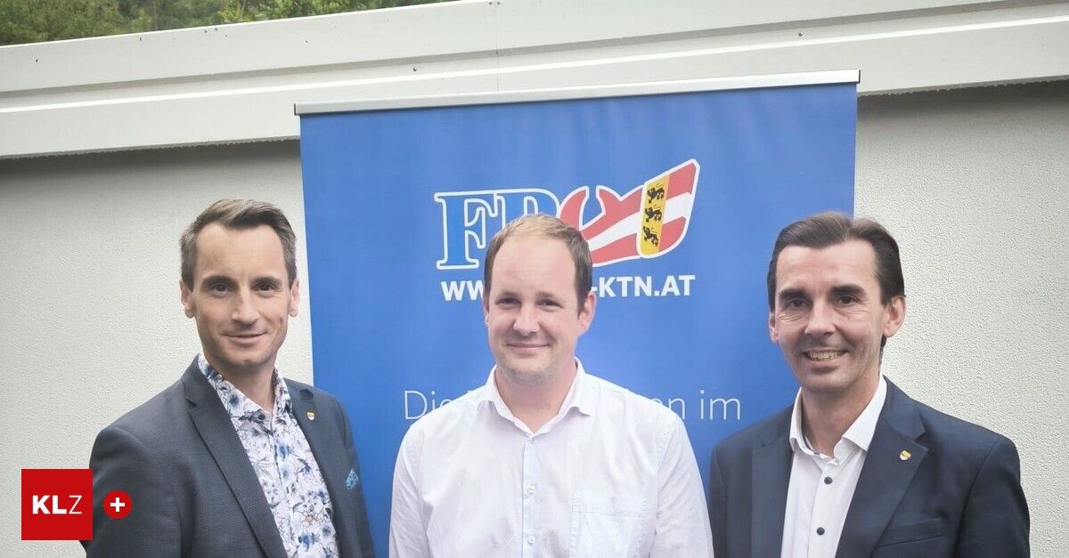 Drei Männer stehen vor einem blauen Banner. Die zentrale Figur trägt ein weißes Hemd, während die anderen Anzüge tragen. Das Banner zeigt ein Logo mit 'FW' und 'WKTN.AT'.