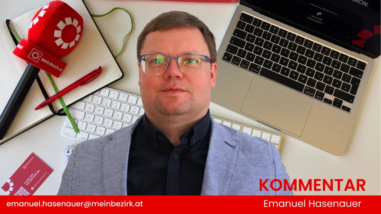 Ein Mann mit Brille und Anzugjacke sitzt vor einem Schreibtisch mit Laptop und Tastatur. Papiere und ein Stift liegen auf dem Schreibtisch. Der Wasserzeichentext lautet KOM@meinbezirk.at.