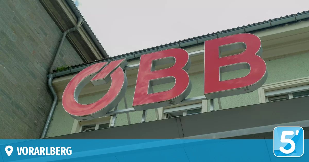 A red sign with the letters BB mounted on the side of a building under a clear sky.