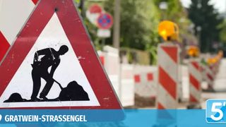 Ein rotes und weißes Schild mit einer Silhouette einer grabenenden Person, mit einem unscharfen Baugelände im Hintergrund.
