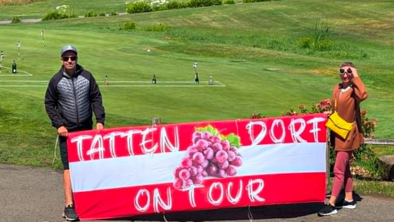 A golf course with a banner saying DorDatten on Tour with an image of grapes.
