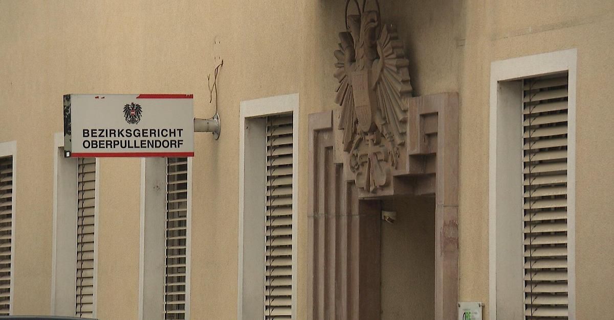 Ein beiges Gebäude mit einem Schild für Arbeitsgericht Pullendorf und einem kunstvollen Design über dem Eingang.