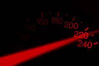 Ein Tachometer mit einem roten Licht, das die Geschwindigkeitszahlen von 160 bis 240 hervorhebt, mit einem roten Strahl, der von der rechten Seite ausgeht.