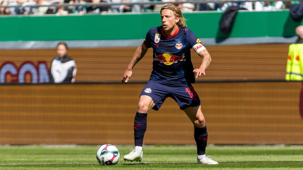 Ein Fußballspieler mit der Nummer 18 auf seinem Trikot läuft auf dem Feld. Er trägt ein blaues Trikot mit einem roten Bullenlogo.
