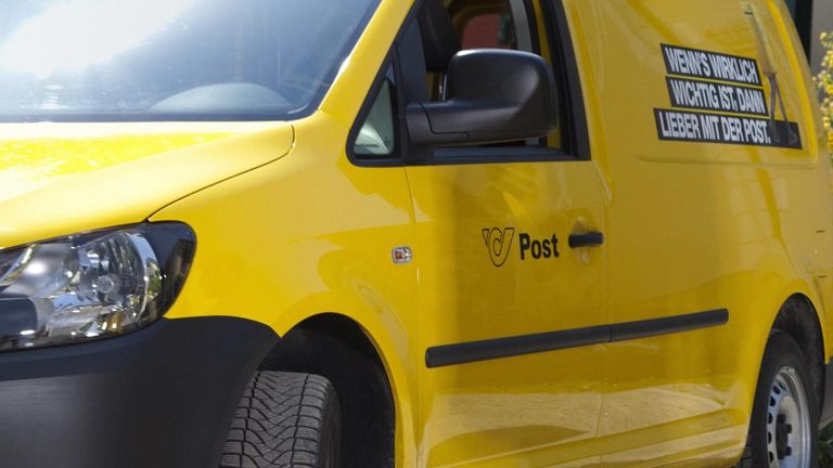 A close-up view of a yellow postal vehicle. The word 'Post' is printed on the side door.