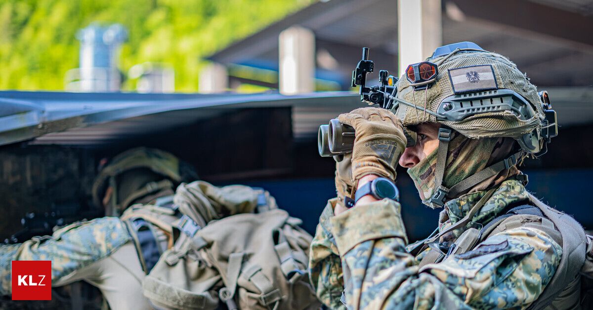 A soldier in camouflage uniform with a helmet and binoculars is looking through the scope, possibly on a mission.