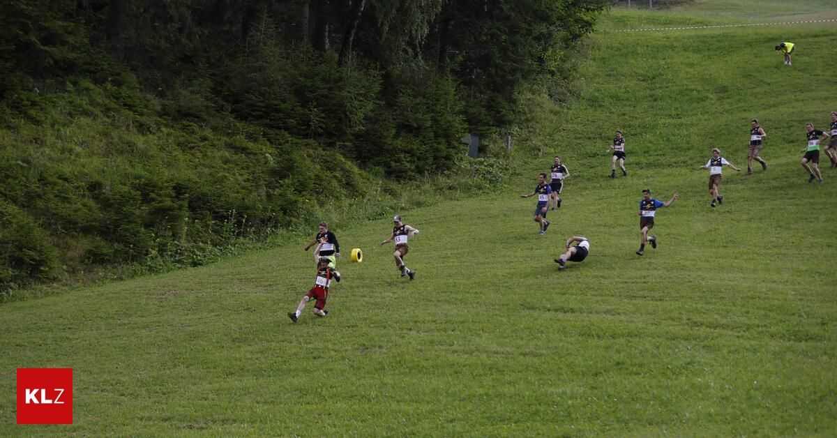 Eine Gruppe von Menschen läuft auf einem Grashang, einige halten eine gelbe Frisbee.