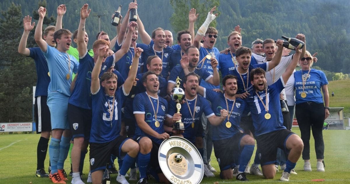 Eine Fußballmannschaft feiert ihren Sieg mit einer Trophäe, Medaillen und Champagnerflaschen, mit einem Berghintergrund und einem klaren blauen Himmel.