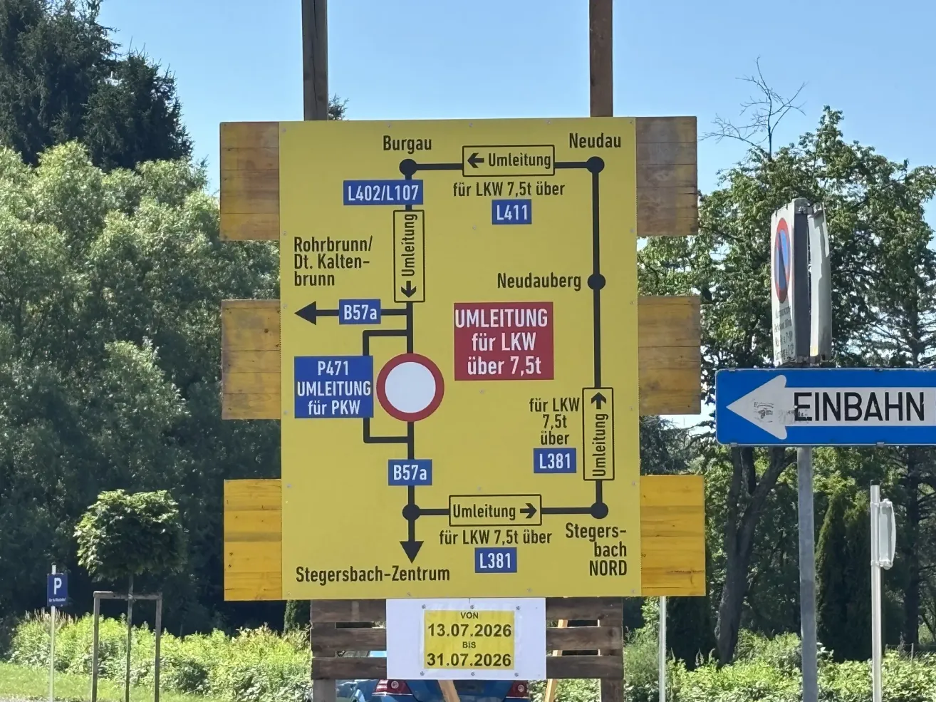 Ein gelbes Schild mit Wegbeschreibungen und Umleitungen für LKW und PKW, mit Daten vom 13.07.2026 bis 31.07.2026. Es enthält Routen wie Burgau, Neudau, Rohrbrunn und Stegersbach-Zentrum.