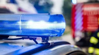 Close-up view of a blue police car light bar with flashing blue lights.